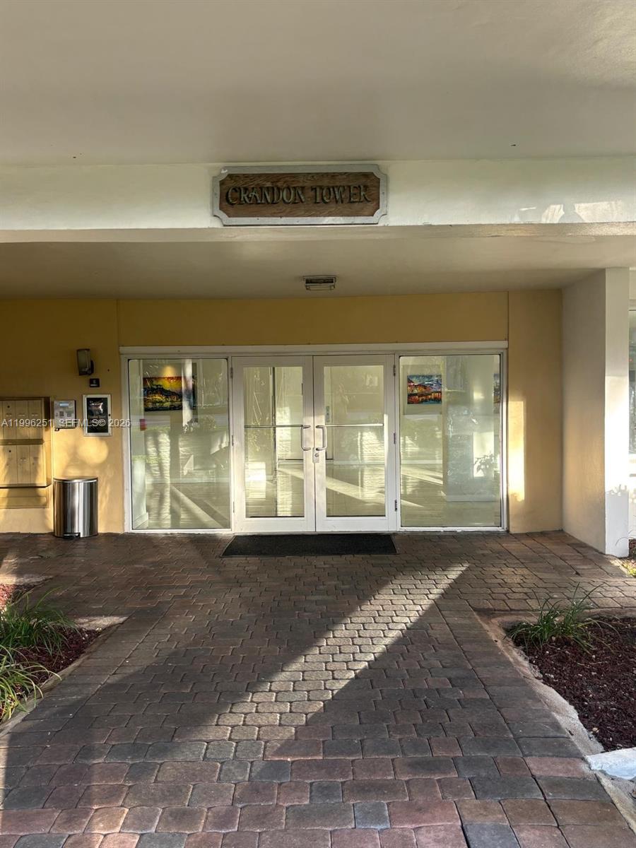 The exterior entrance of Crandon Tower features double glass doors and a paved walkway — 555 Crandon Blvd # 43, Key Biscayne FL 33149, KEY BISCAYNE, FL
