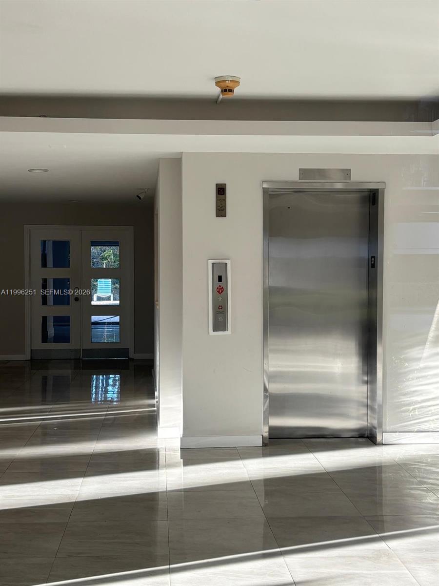 A modern building interior features a stainless steel elevator and a white double door — 555 Crandon Blvd # 43, Key Biscayne FL 33149, KEY BISCAYNE, FL