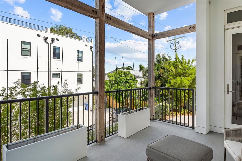 A balcony features a black metal railing, wooden support beams, and two white rectangular planters — 91 DAVIS BOULEVARD UNIT 204, TAMPA, FL