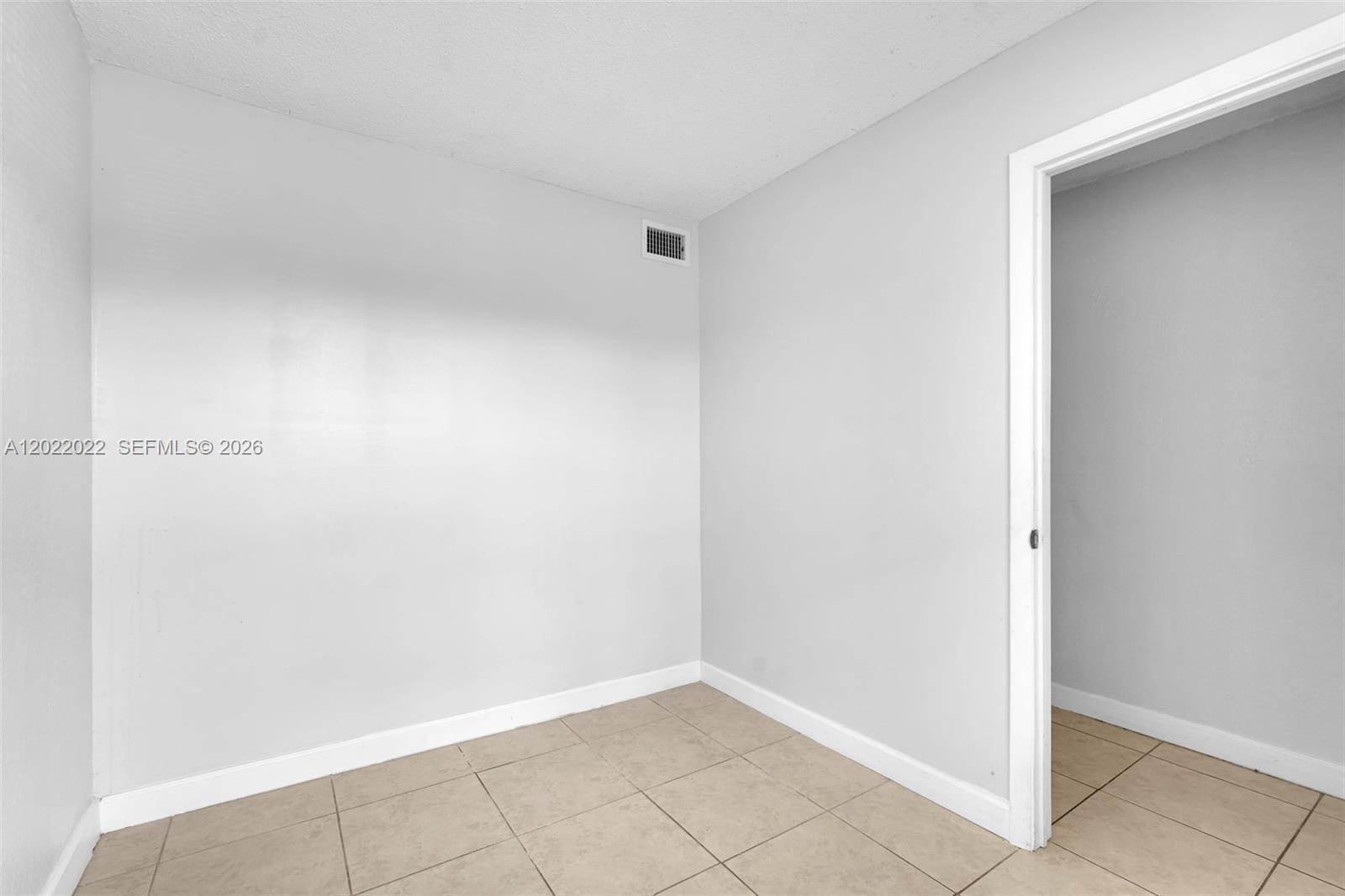 An empty room features light-colored walls, a tiled floor, and a doorway leading elsewhere — 400 NW 65th Ave # 213, Margate FL 33063, MARGATE, FL