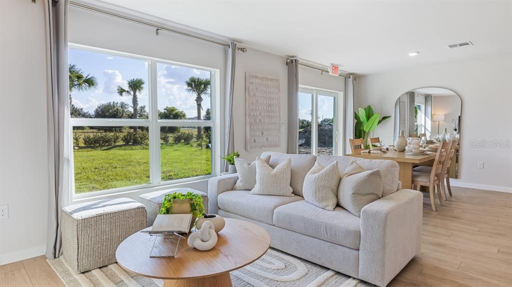 A living room with a sofa, coffee table, and dining area overlooking a grassy yard — 1529 HARMON DRIVE, PORT CHARLOTTE, FL