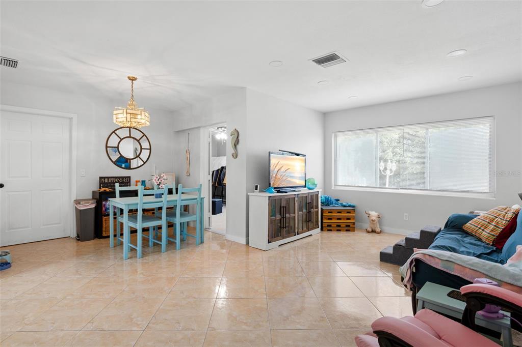 A dining area and living space feature light tile flooring, white walls, and a window — 2536 KEENE PARK DRIVE, LARGO, FL