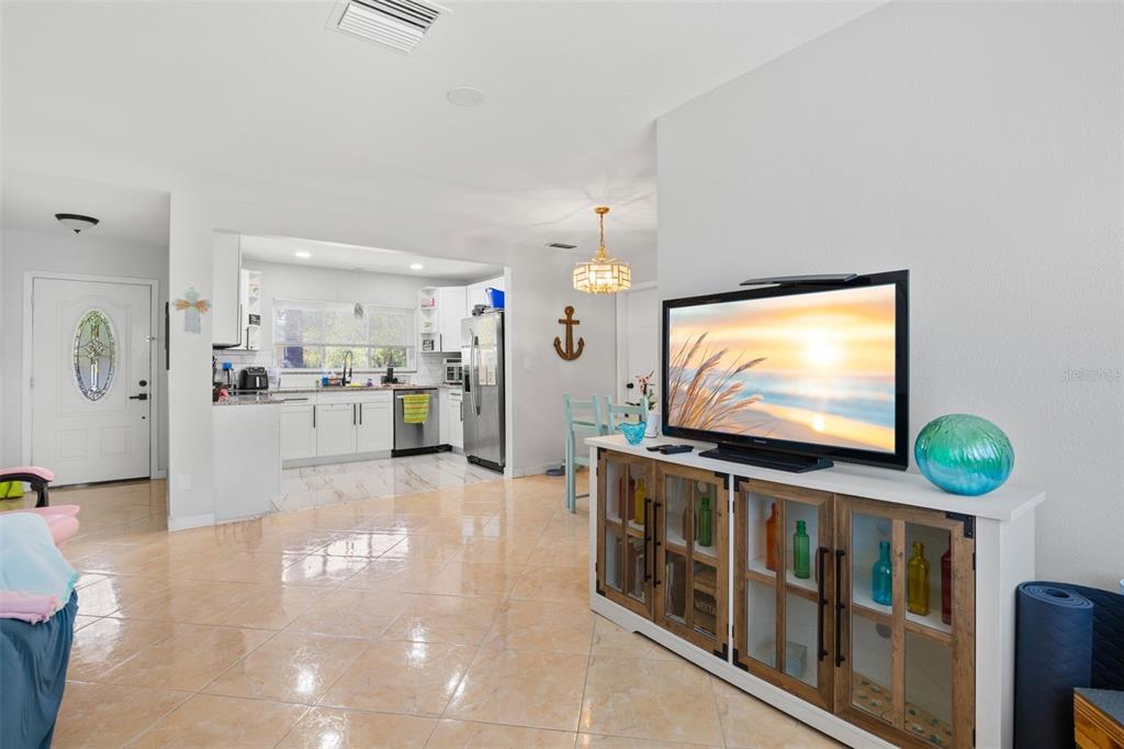 A living room with tile flooring features a television on a wooden media console — 2536 KEENE PARK DRIVE, LARGO, FL