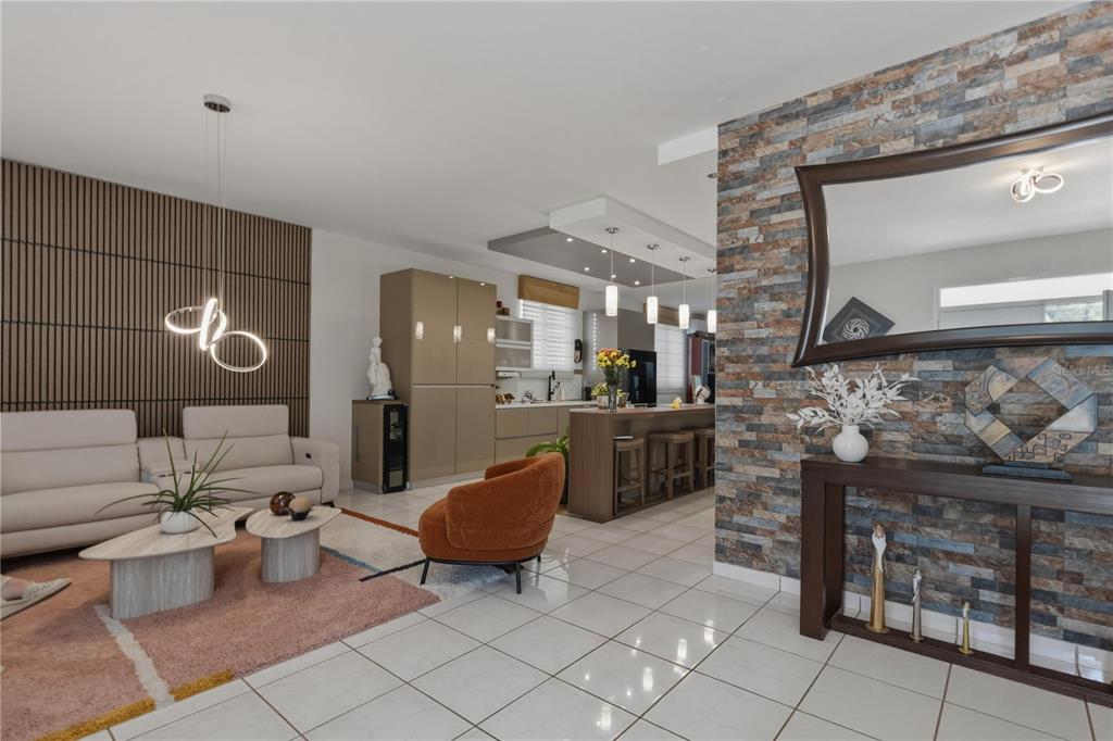 An open-concept living room and kitchen featuring a stone accent wall and modern furniture — 149 YUISA ST.  LOMAS Lot 76, MANATI, PR