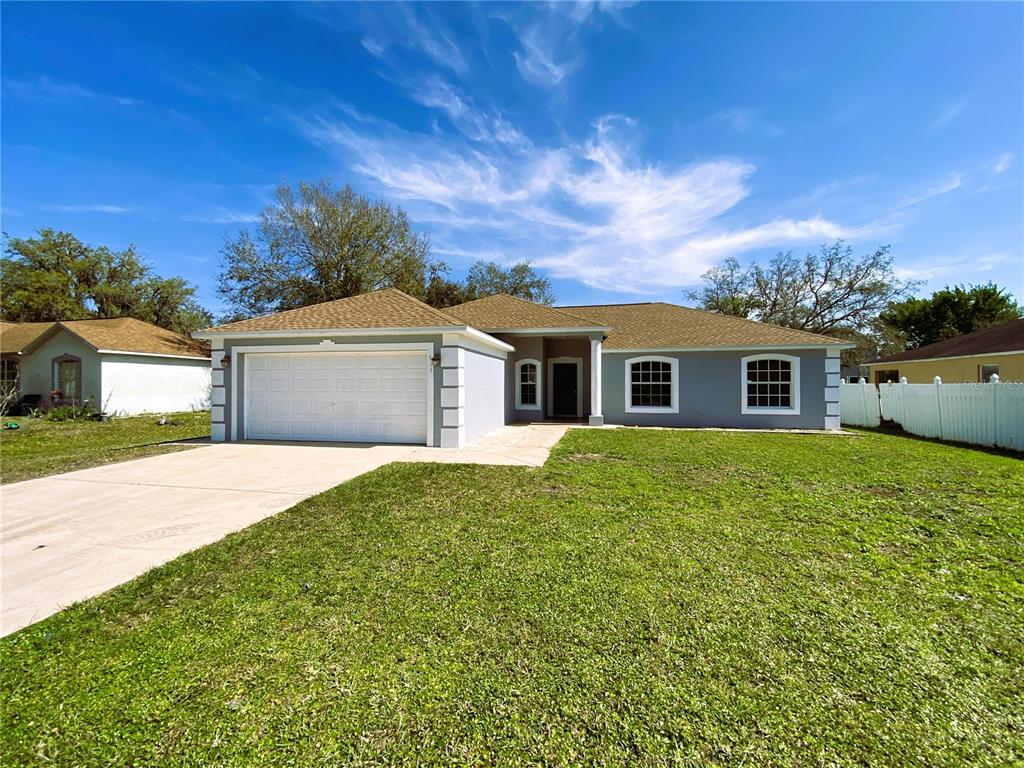 A single-story house with a gray exterior, a two-car garage, and a brown shingled roof — 311 BACCARAT COURT, KISSIMMEE, FL