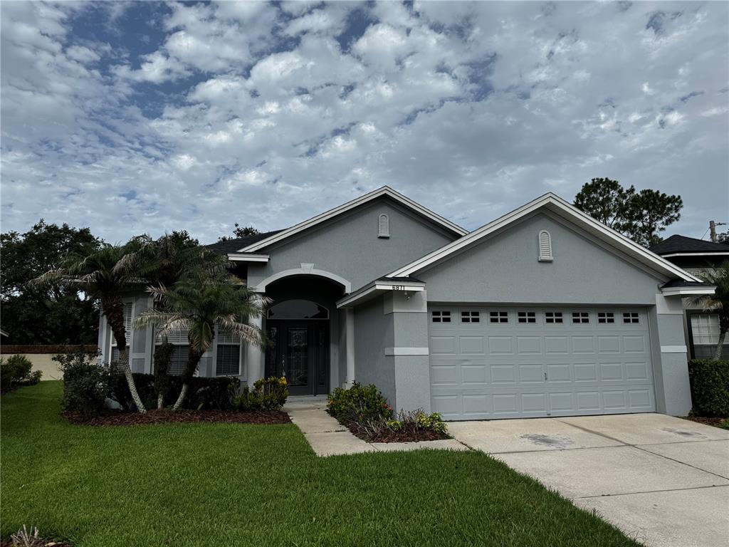 A single-story gray house with a two-car garage and a front walkway — 6871 EAGLE RIDGE LOOP, LAKELAND, FL