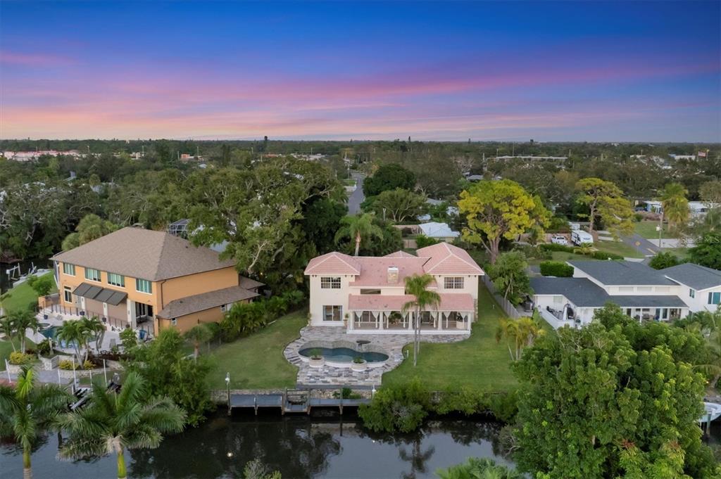 An aerial view shows a house with a tiled roof, a swimming pool, and a driveway — 7300 COVE TERRACE, SARASOTA, FL