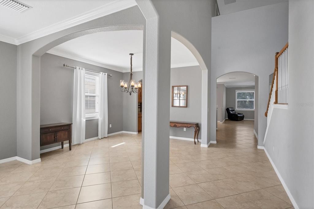 An interior view shows a tiled foyer leading to a dining area and staircase — 1878 MESIC HAMMOCK WAY, VENICE, FL