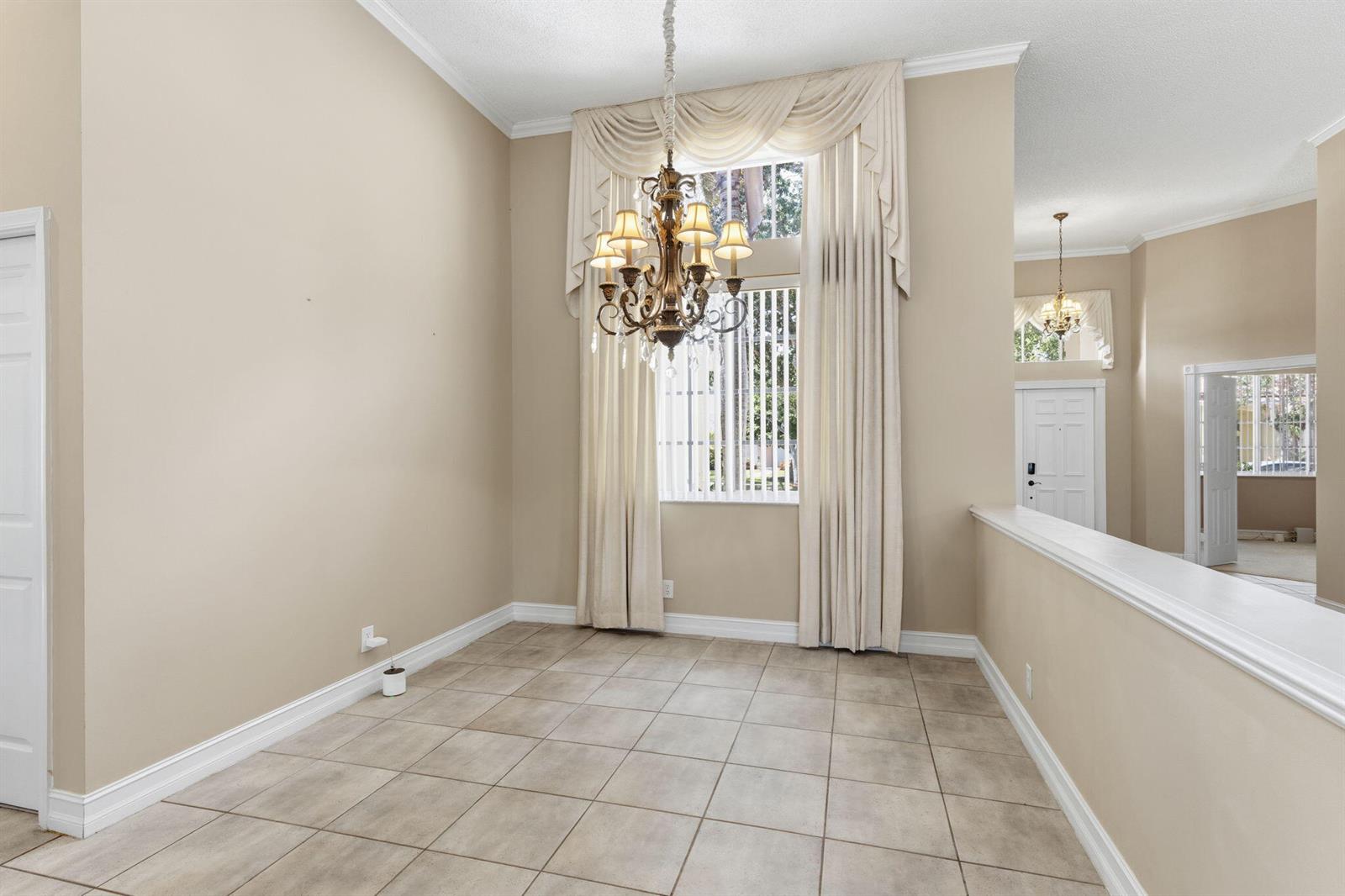 A dining room with tile floors, a chandelier, and tall windows with draped curtains — 832 Heritage Drive, Weston FL 33326, WESTON, FL