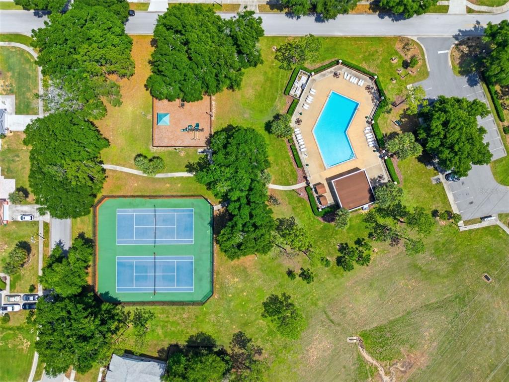 An aerial view shows a community park with a swimming pool, tennis courts, and playground — 14715 GREATER PINES BOULEVARD, CLERMONT, FL
