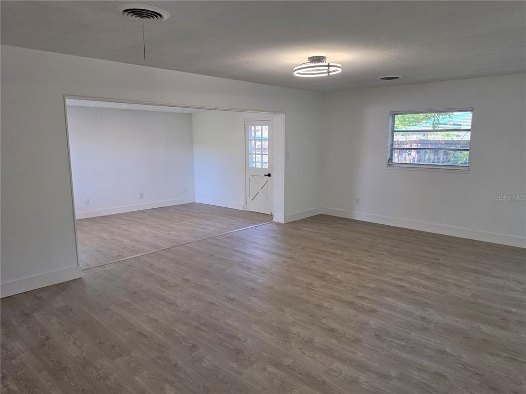 An interior view shows a living area with light wood-look flooring and a white door — 640 WESTWARD CIRCLE, DAYTONA BEACH, FL