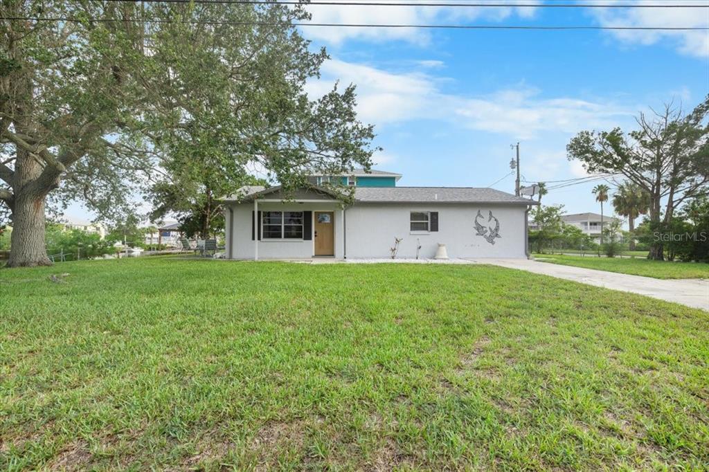 A single-story gray house with a front porch sits on a large grassy lot — 3478 COMPANERO ENTRA, HERNANDO BEACH, FL