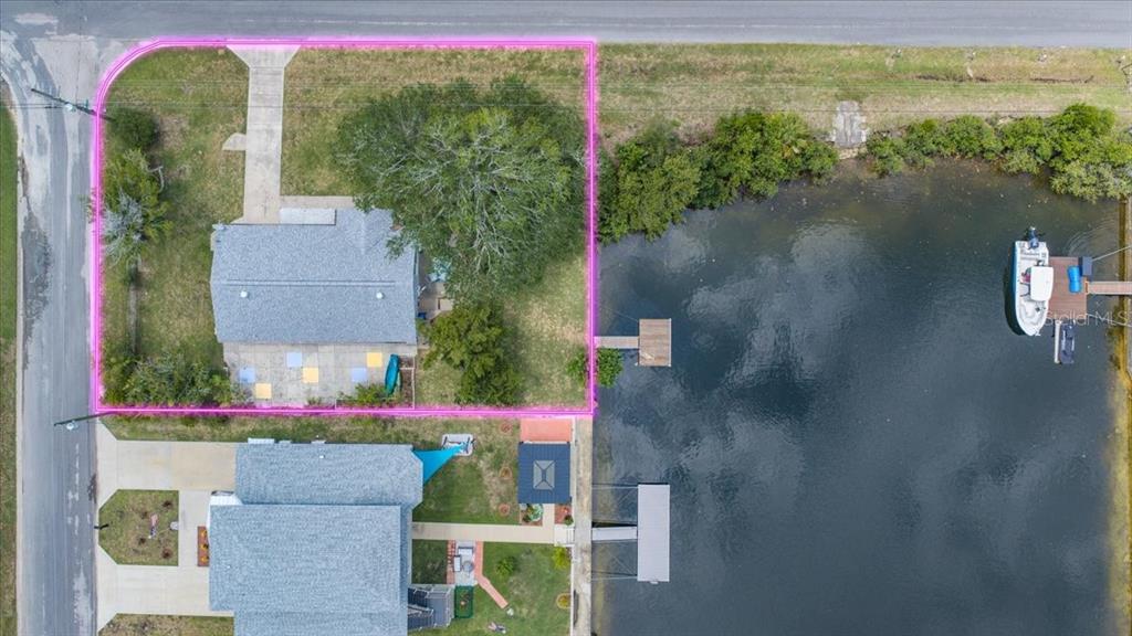 An aerial view shows a waterfront house with a dock and a fenced yard — 3478 COMPANERO ENTRA, HERNANDO BEACH, FL