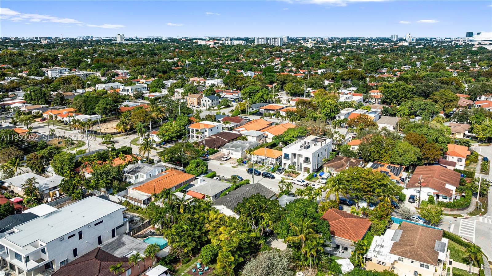 An aerial view shows a residential neighborhood with houses, lush trees, and paved streets — 1428 SW 20th St, Miami FL 33145, MIAMI, FL
