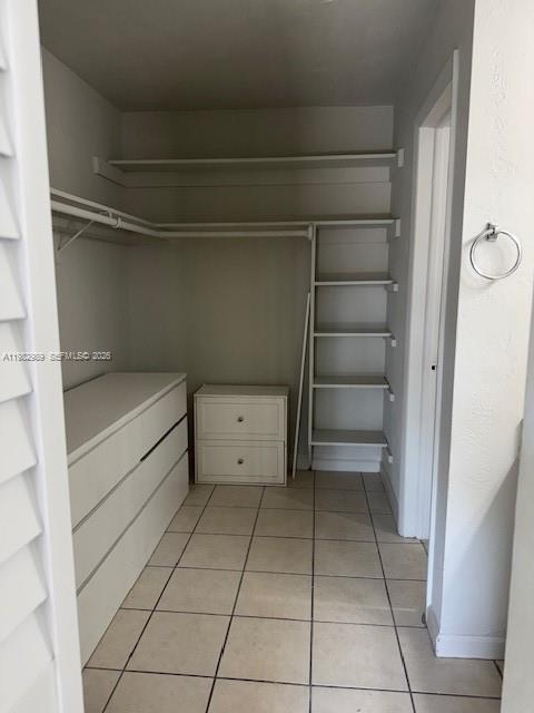 A walk-in closet features white built-in shelving, a dresser, and light-colored floor tiles — 8601 SW 68th Ct # 23, Pinecrest FL 33156, PINECREST, FL