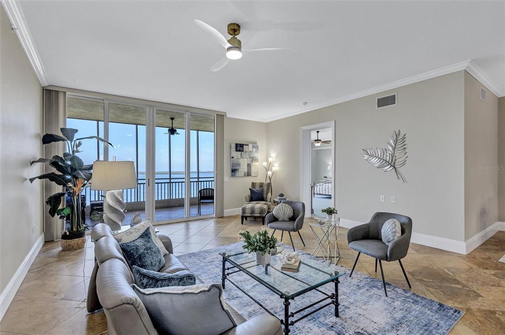 A living room features tile floors, a glass coffee table, and a balcony overlooking water — 2925 TERRA CEIA BAY BOULEVARD UNIT 2902, PALMETTO, FL