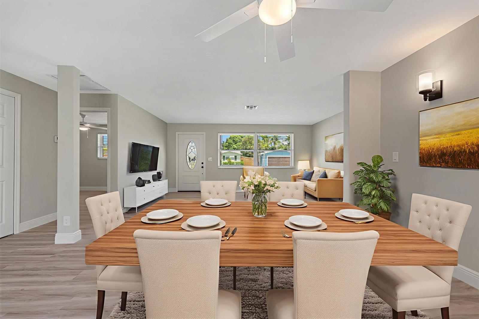 A dining room with a wooden table and tufted chairs opens into a living area — 204 Circle E, Jupiter FL 33458, JUPITER, FL