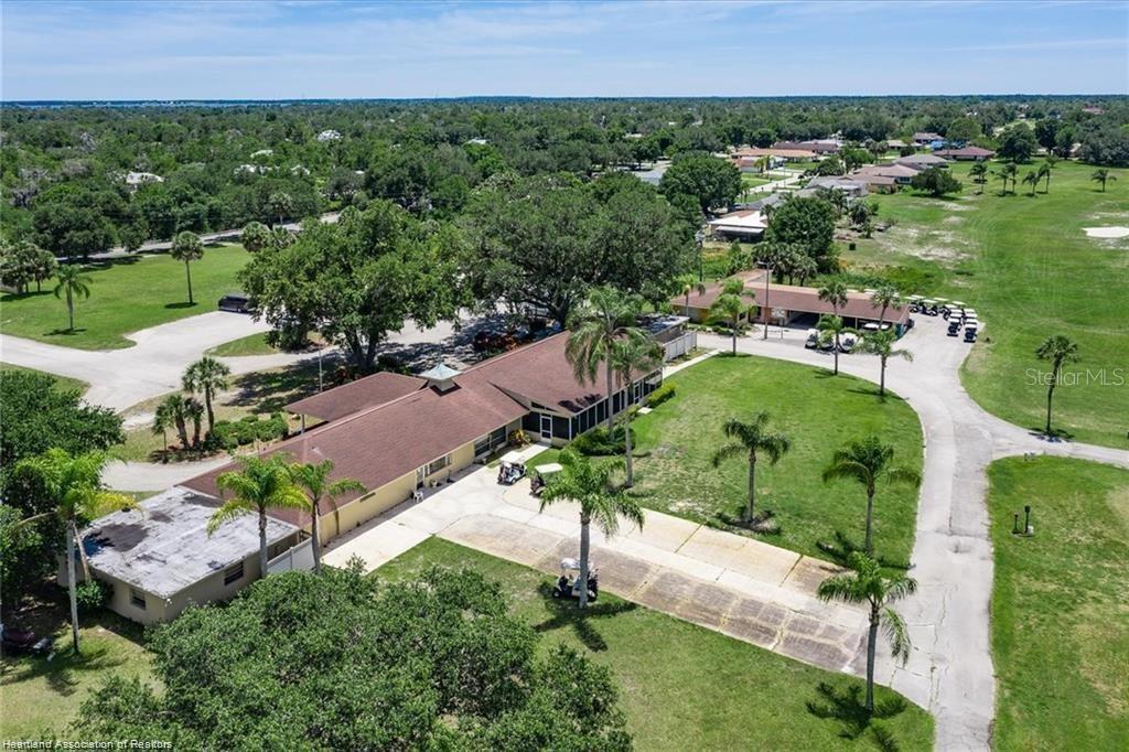 An aerial view shows a single-story building with a brown roof surrounded by palm trees — 3603 PLACID LAKES BOULEVARD, LAKE PLACID, FL