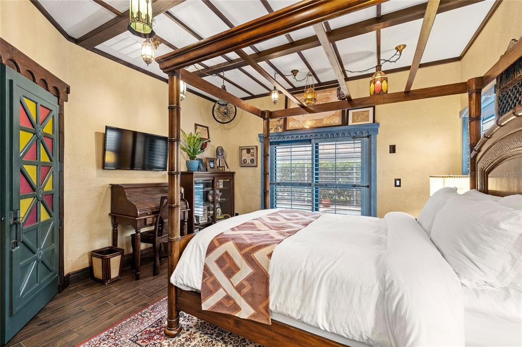 A bedroom features a four-poster wooden bed, a roll-top desk, and a stained-glass door — 16644 CARIBBEAN BREEZE WAY, CLERMONT, FL