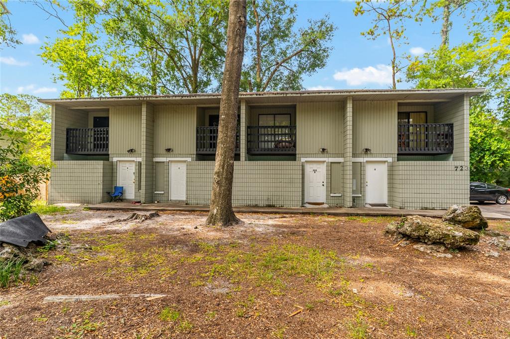 A two-story apartment building exterior features four white doors and upper-level balconies — 723 SW 69TH STREET, GAINESVILLE, FL
