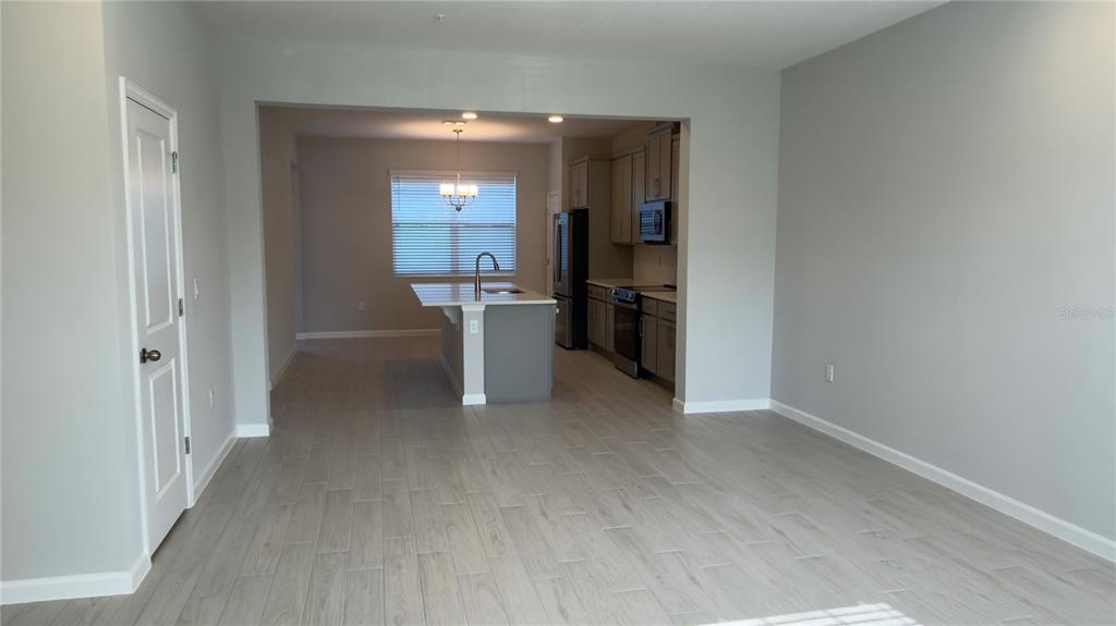 A kitchen with a center island, gray cabinets, and light-colored wood-look tile flooring — 438 LADY PALM STREET, APOPKA, FL