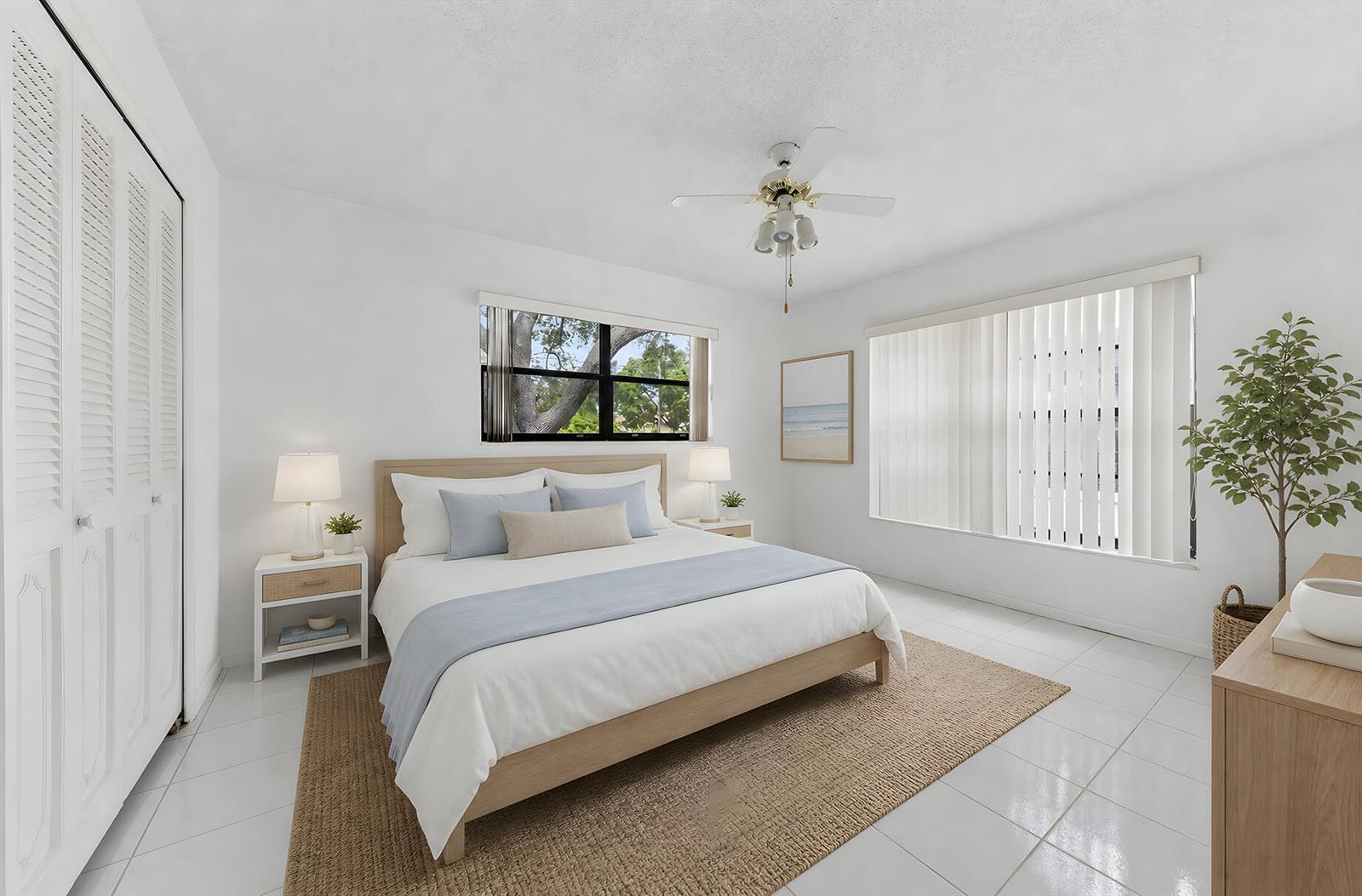 A bedroom features a light wood bed frame, white tile floors, and a ceiling fan — 9795 Tabebuia Tree Drive # B, Boynton Beach FL 33436, BOYNTON BEACH, FL