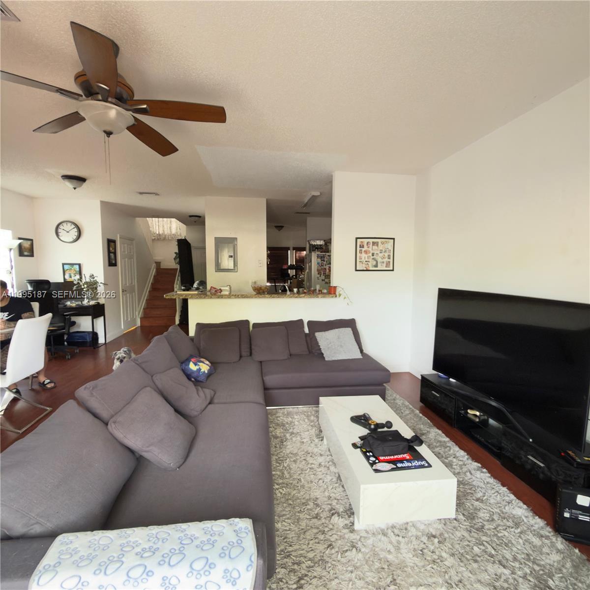 A living room features a grey sectional sofa, a white coffee table, and a large television — 16029 Emerald Cove Rd, Weston FL 33331, WESTON, FL