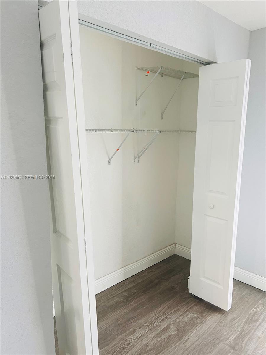 A closet with white bi-fold doors, wire shelving, and wood-look flooring — 8401 NW 20th Ct, Sunrise FL 33322, SUNRISE, FL