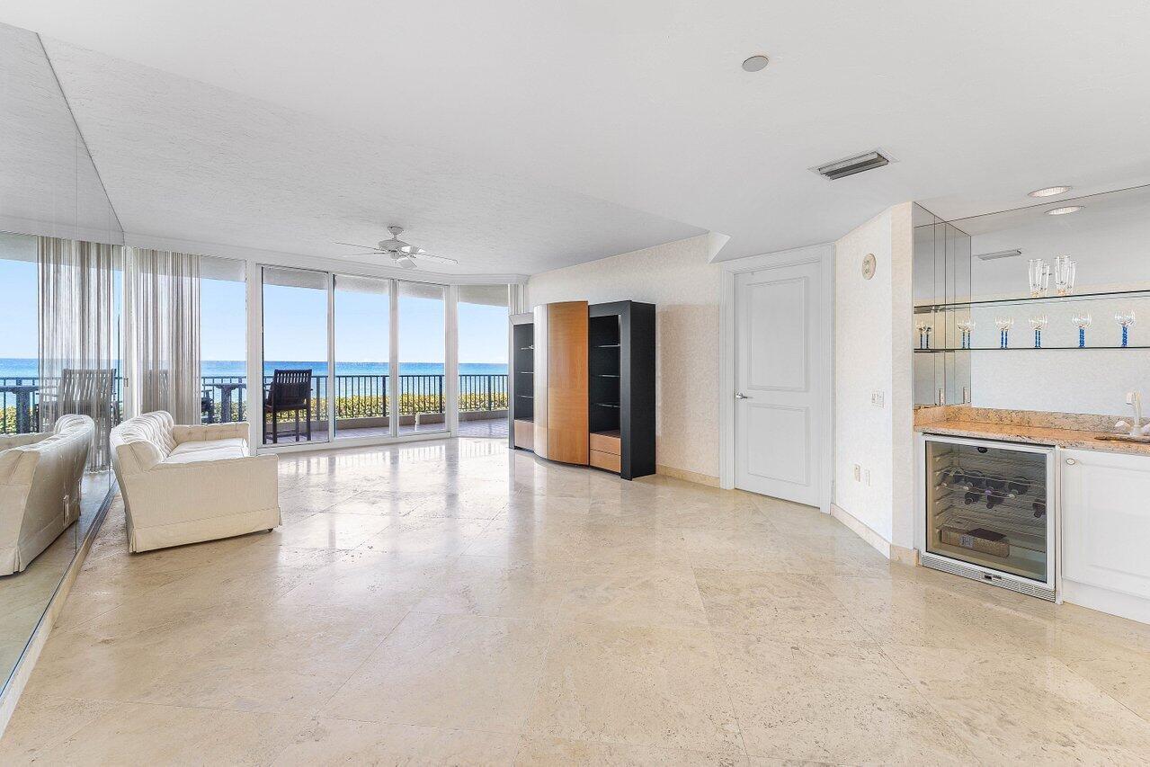 A living room with tile floors, a wet bar, and sliding doors overlooking the ocean — 800 Ocean Drive # 204, Juno Beach FL 33408, JUNO BEACH, FL