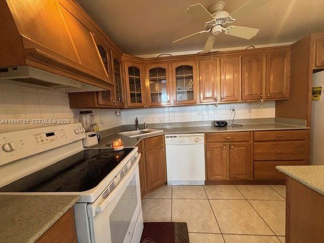 A kitchen features wood cabinets, a white stove, a white dishwasher, and tile flooring — 1400 S Ocean Dr # 304, Hollywood FL 33019, HOLLYWOOD, FL