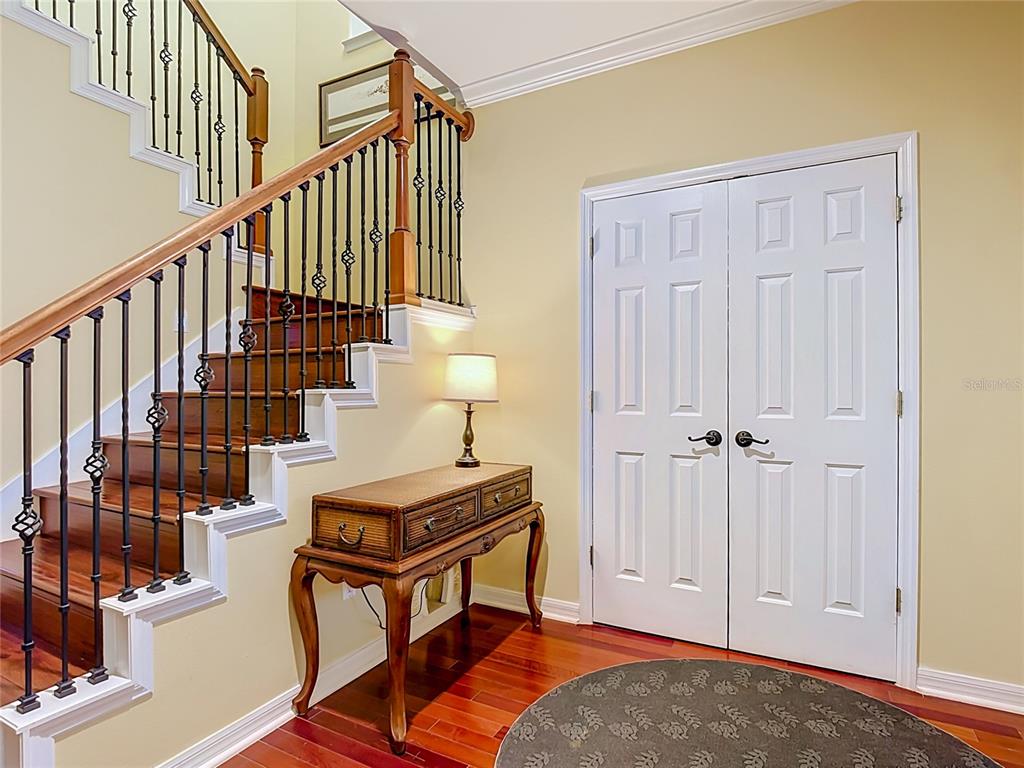 An entryway features a wooden staircase with iron railings, a console table, and double doors — 828 MORNING GLORY LANE, CELEBRATION, FL
