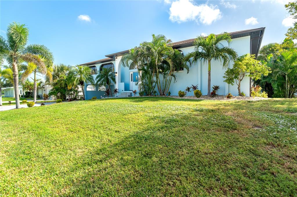 A light blue two-story house with palm trees and a large front lawn — 10467 MARION STREET, ENGLEWOOD, FL