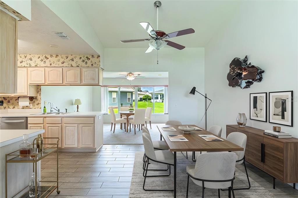 A dining area with a wooden table and chairs sits adjacent to a kitchen — 2260 GRAND CYPRESS DRIVE, LAKELAND, FL