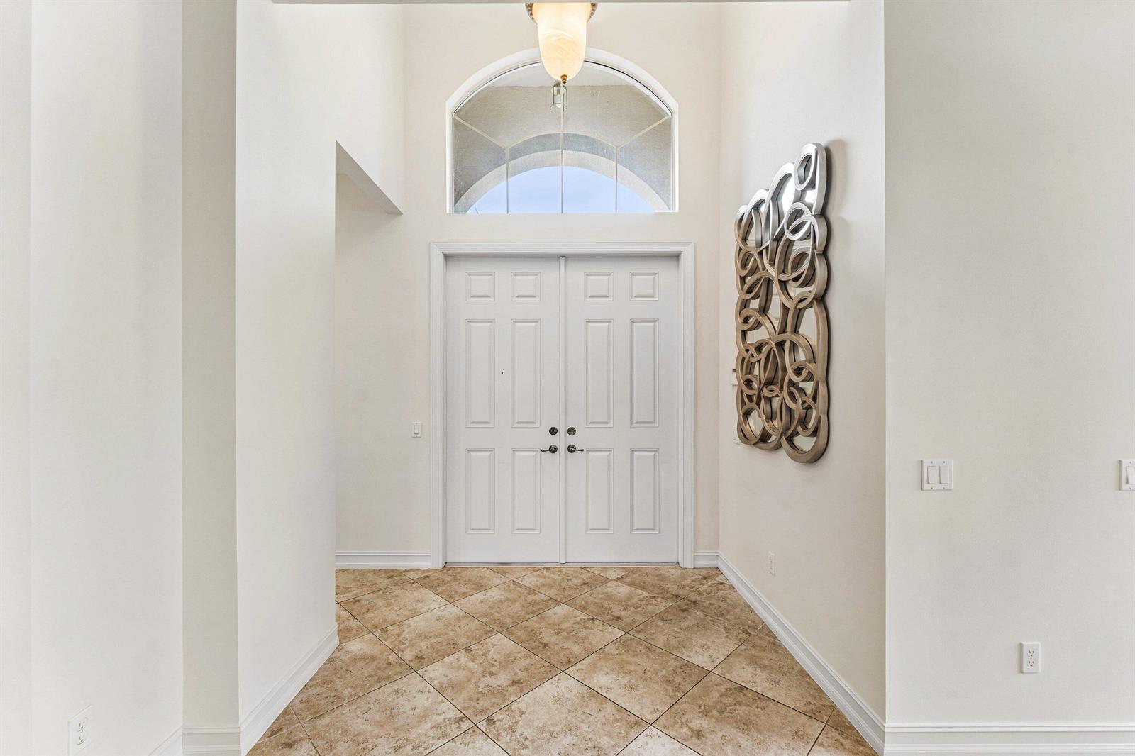 An entryway features double white doors, a tiled floor, and a decorative wall sculpture — 6968 Corning Circle, Boynton Beach FL 33437, BOYNTON BEACH, FL