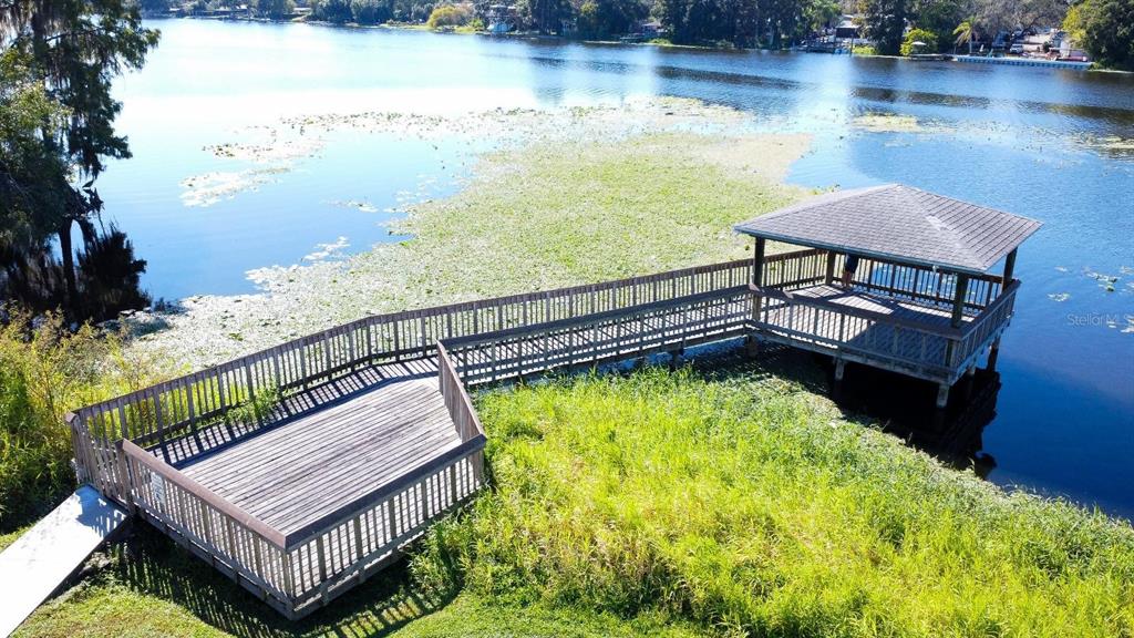An elevated wooden deck and gazebo extend over a lake filled with lily pads — 4148 DOLPHIN DRIVE UNIT 3, TAMPA, FL