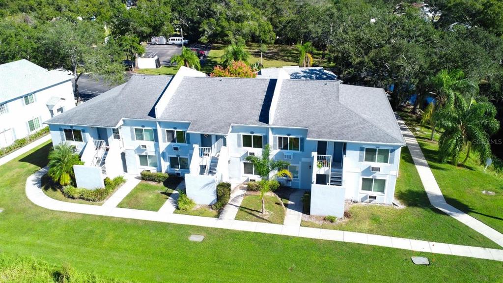 An aerial view of a two-story apartment building with a gray shingled roof — 4148 DOLPHIN DRIVE UNIT 3, TAMPA, FL