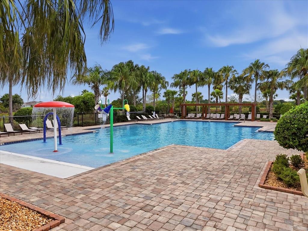 A swimming pool with a mushroom fountain and lounge chairs on a brick patio — 2934 LONG POND DRIVE, LAKELAND, FL