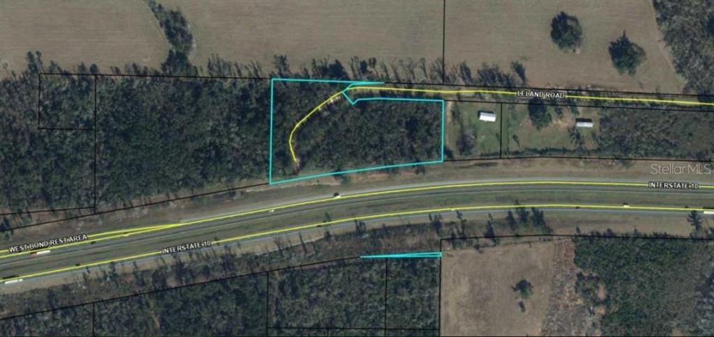 This aerial map shows a plot of land outlined in blue next to a highway — LELAND RD, MARIANNA, FL