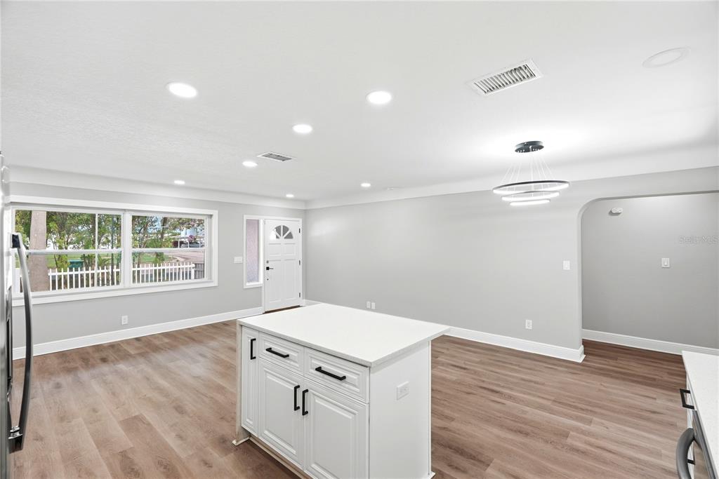 A kitchen island with white cabinets sits in a room with light gray walls — 1628 S HIGHLAND AVENUE, CLEARWATER, FL