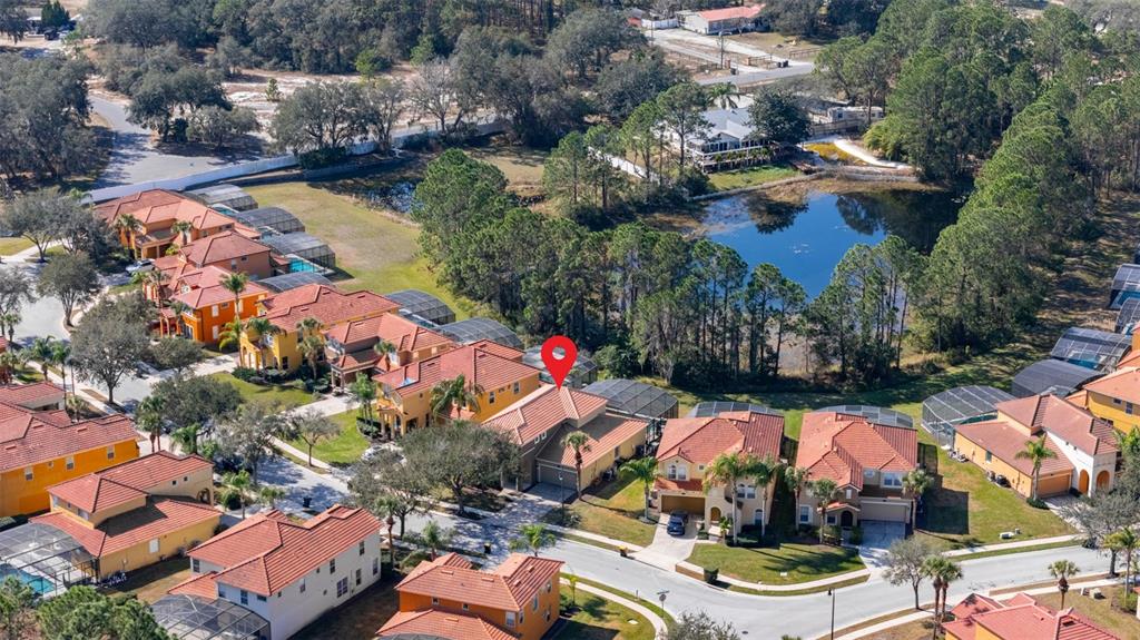 An aerial view shows a suburban neighborhood with houses featuring red tile roofs — 113 TIGER LILY COURT, DAVENPORT, FL