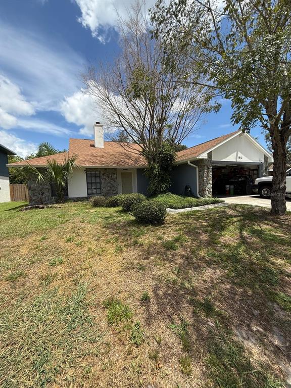 A single-story house with a stone facade, a brown shingled roof, and an attached garage — 1912 FIRETHORN COURT, BRANDON, FL