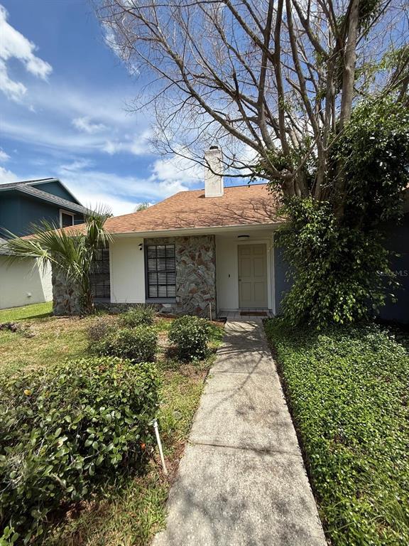 A single-story house with a stone facade, a tan front door, and a concrete walkway — 1912 FIRETHORN COURT, BRANDON, FL