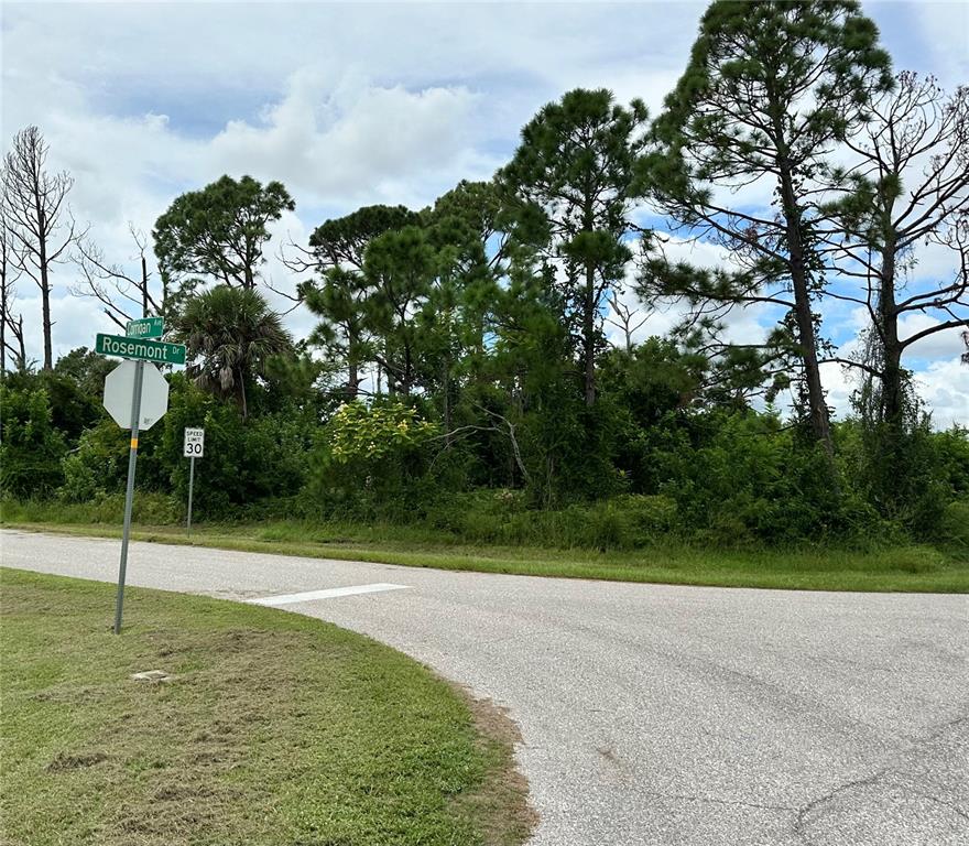 A street corner with a Rosemont Drive sign and a speed limit sign near trees — 11120 CORRIGAN AVENUE, ENGLEWOOD, FL