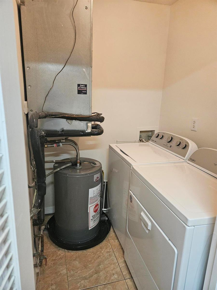 A utility closet containing a water heater, an HVAC air handler, and a laundry set — 2050 Oleander Boulevard # 108, Fort Pierce FL 34950, FORT PIERCE, FL