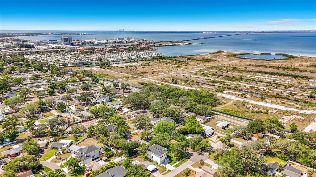 An aerial view shows a residential neighborhood near a large body of water and bridge — 4732 W WALLCRAFT AVENUE, TAMPA, FL