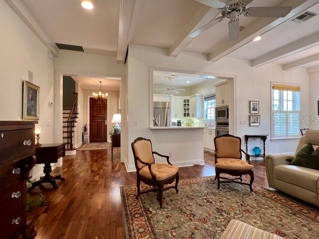 A living room with hardwood floors, two armchairs, and an open view into a kitchen — 622 PENN PLACE, WINTER PARK, FL