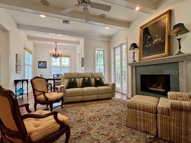 A living room features a fireplace, beige sofa, patterned rug, and a ceiling fan — 622 PENN PLACE, WINTER PARK, FL