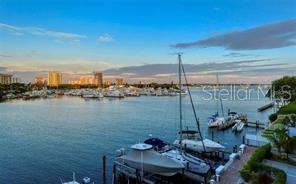 A view of a marina with several boats docked in the water under a blue sky — 650 GOLDEN GATE POINT UNIT 301, SARASOTA, FL