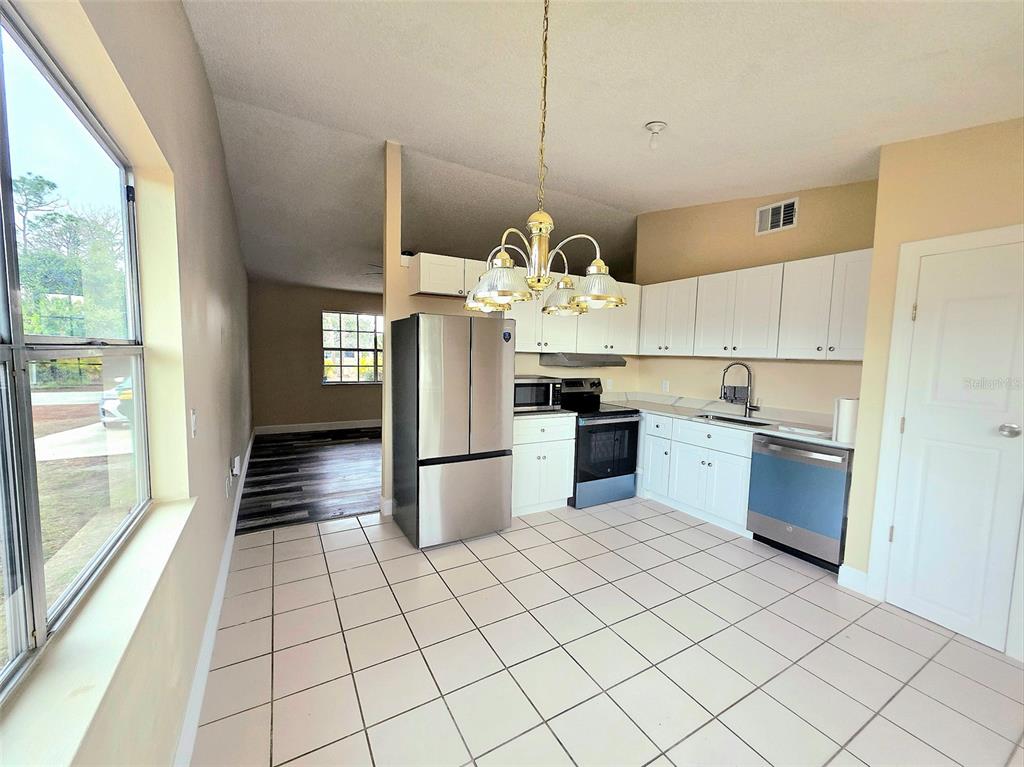 A kitchen with white cabinets, stainless steel appliances, and tile flooring — 12091 CROSSGATE AVENUE, PORT CHARLOTTE, FL