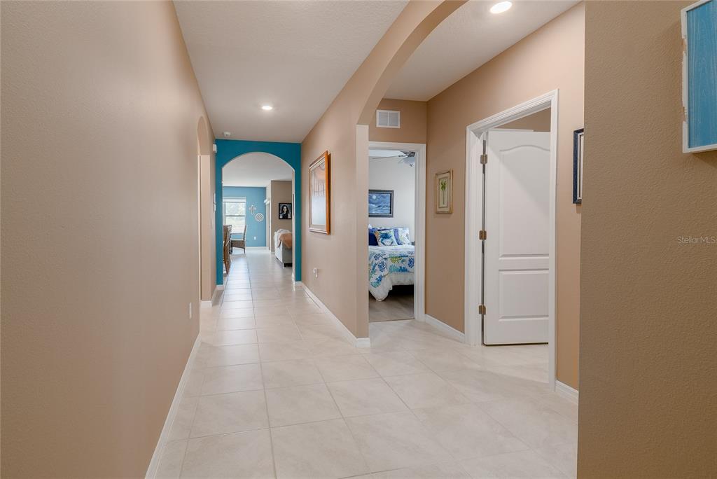 A tiled hallway leads to a living area with a bedroom doorway on the right — 5688 SILTSTONE STREET, LAKELAND, FL
